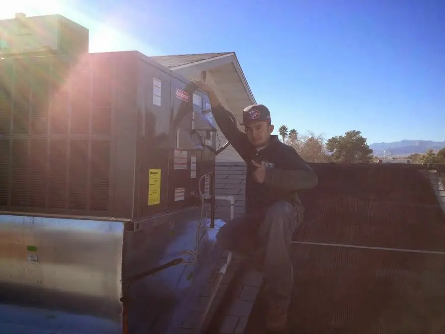 HVAC technician performing Heat Pump Repair on a rooftop unit in Waukee